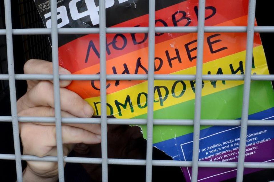 Poster déchiré décrétant "L'amour est plus fort que l'homophobie" déchirée par un militant à Moscou.